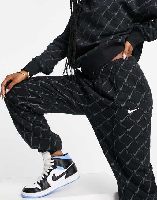 Nike oversized joggers in black with all over swoosh print