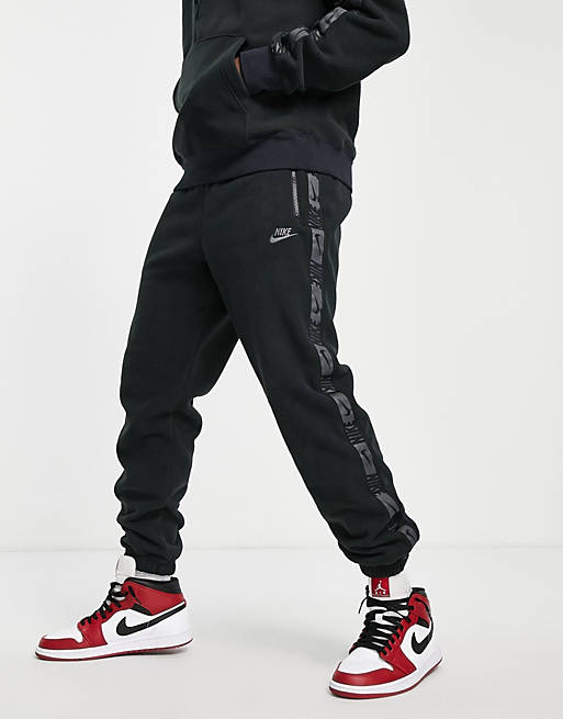Nike Repeat logo taping polar fleece cuffed joggers in black 