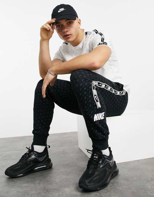 Nike - Repeat Pack - Joggingbroek met all-over logoprint, logobies en boorden in zwart