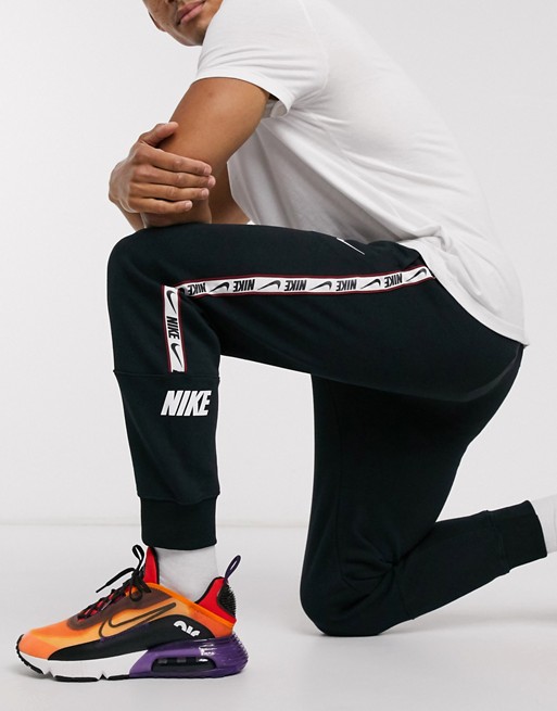 Nike Repeat Pack logo taping cuffed joggers in black | ASOS