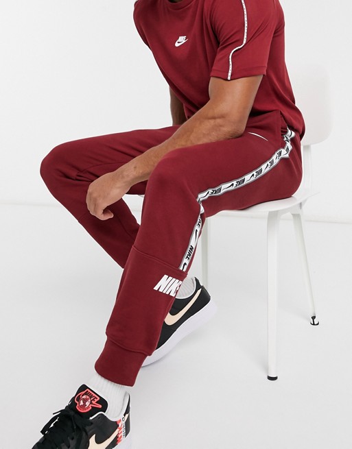 Nike Repeat Pack logo taping cuffed joggers in burgundy