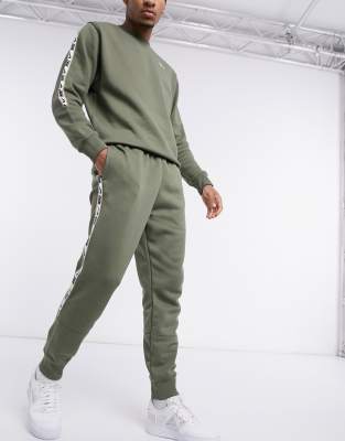 nike repeat pack logo taping cuffed joggers in khaki