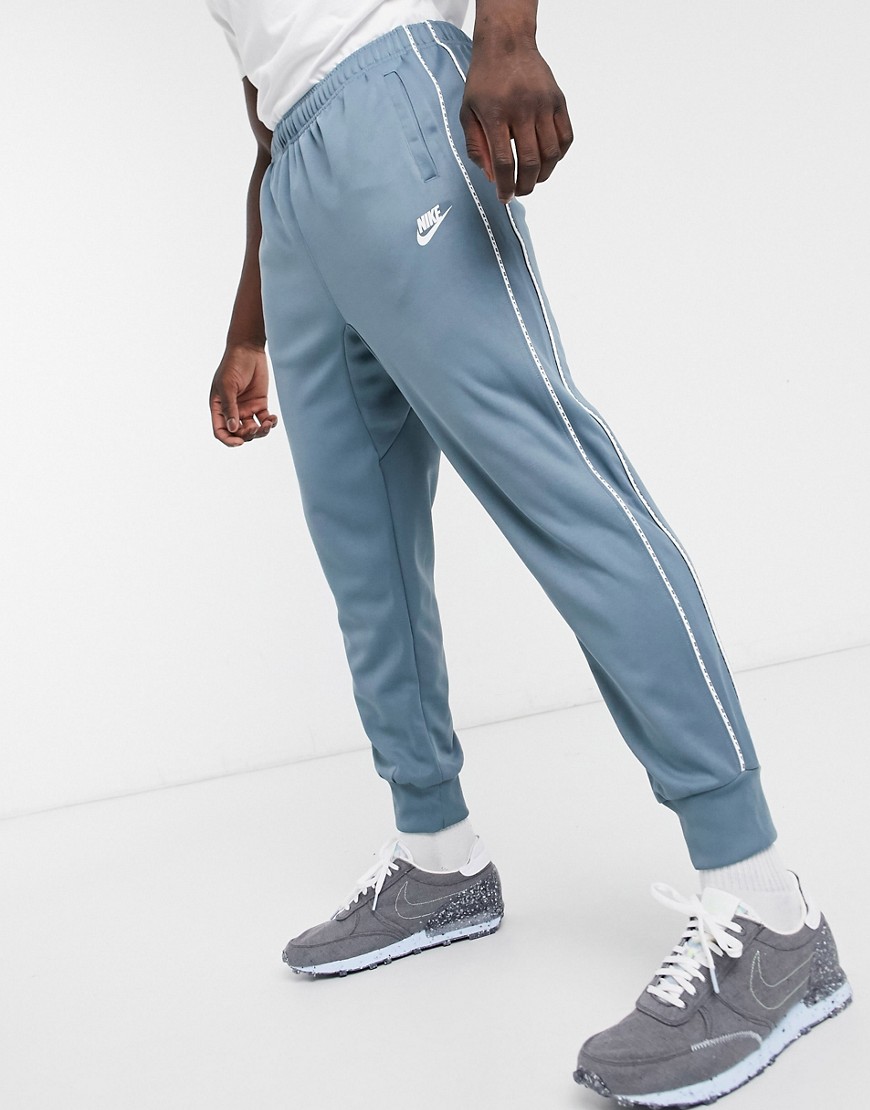Nike Repeat Pack logo taping polyknit cuffed joggers in steel blue
