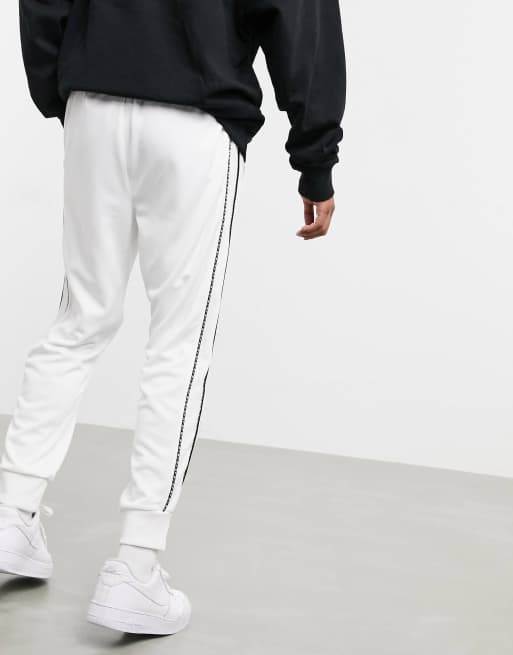 Nike Repeat Pack polyknit logo taping cuffed joggers in white | ASOS