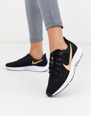 black nike trainers with gold tick 