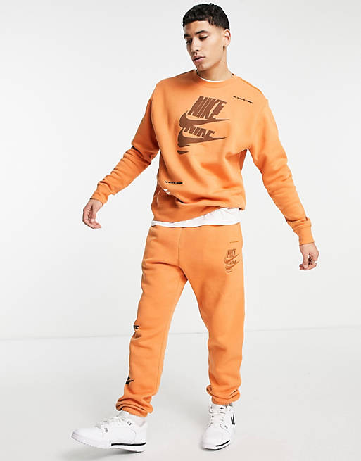 Nike Sport Essentials Multi Futura logo fleece tracksuit in orange 