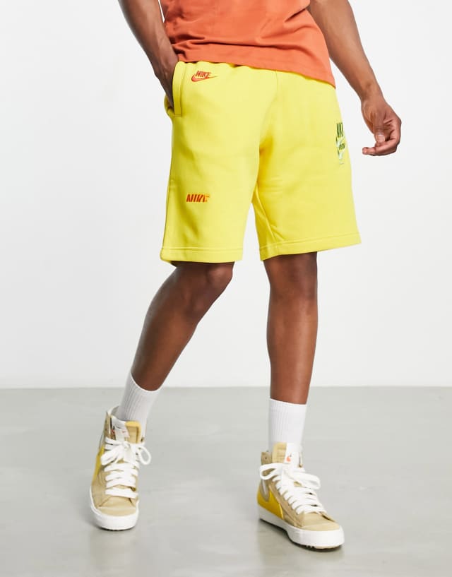 Nike Sport Essentials multi-futura logo fleece shorts in yellow