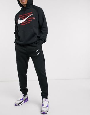Nike Swoosh cuffed trackies in black | ASOS