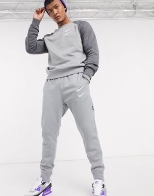Nike Swoosh logo cuffed joggers in grey 