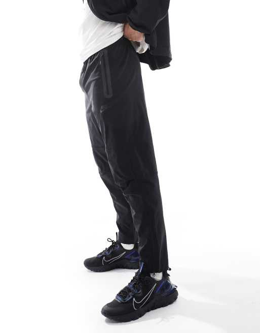 Nike Tech Woven open hem trousers in black | ASOS