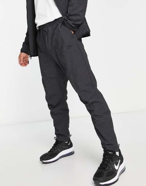 Nike textured tech fleece woven trousers in black ASOS