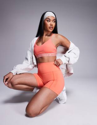 Nike Training - Gym Life Swoosh Indy Dri-FIT - Sport-BH in Koralle mit leichter Stützkraft-Rosa