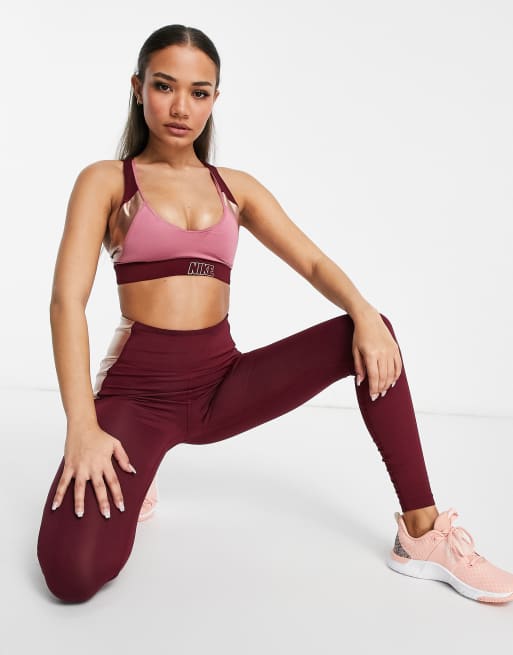 Nike Training Indy light support logo metallic sports bra in burgundy and  pink