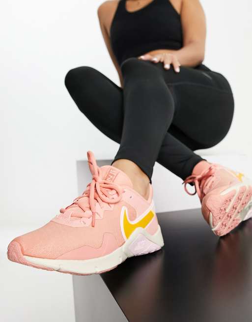 Nike Training – Legend Essential 2 – Guldfärgade och rosa sneakers