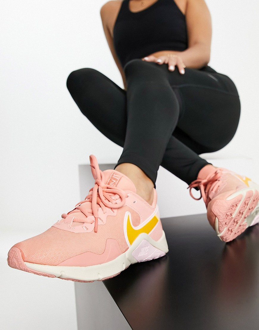 Nike Training Legend Essential 2 trainers in pink and gold