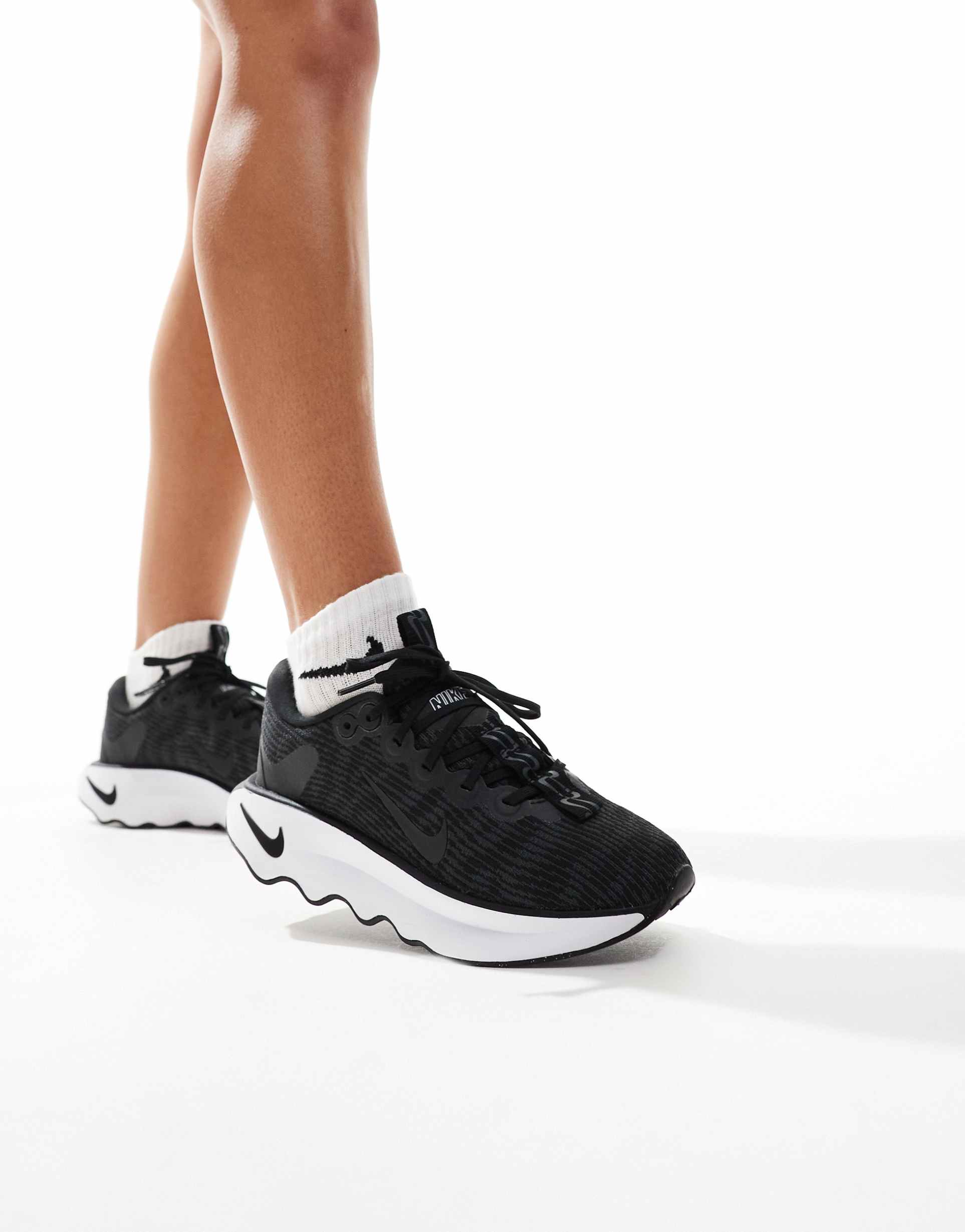 nike training motiva sneakers in black and white