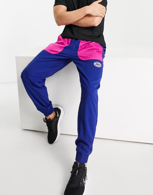 Nike Training - Sport Clash - Sneldrogende Dri-FIT joggingbroek van geweven stof in koninklijk blauw