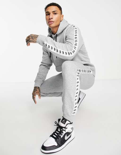 Nike Trainingsanzug Set aus Fleece in Grau mit Zierstreifen mit sich wiederholendem Logo