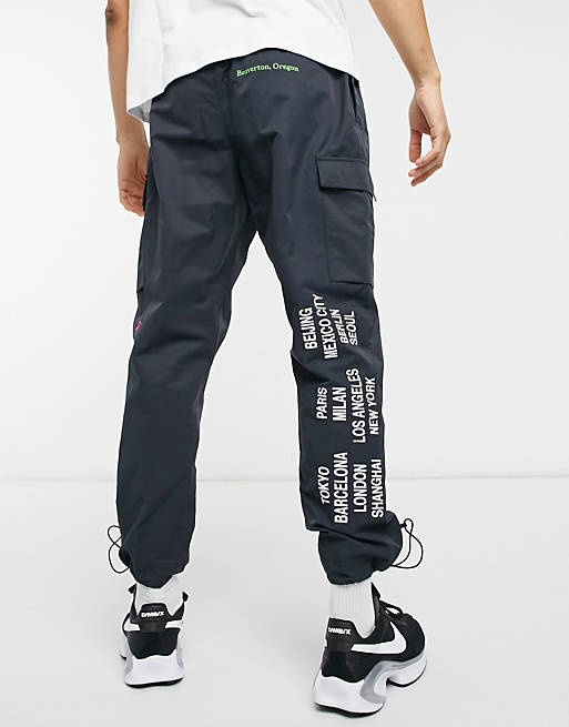 Nike World Tour Pack graphic woven cuffed cargo joggers in black