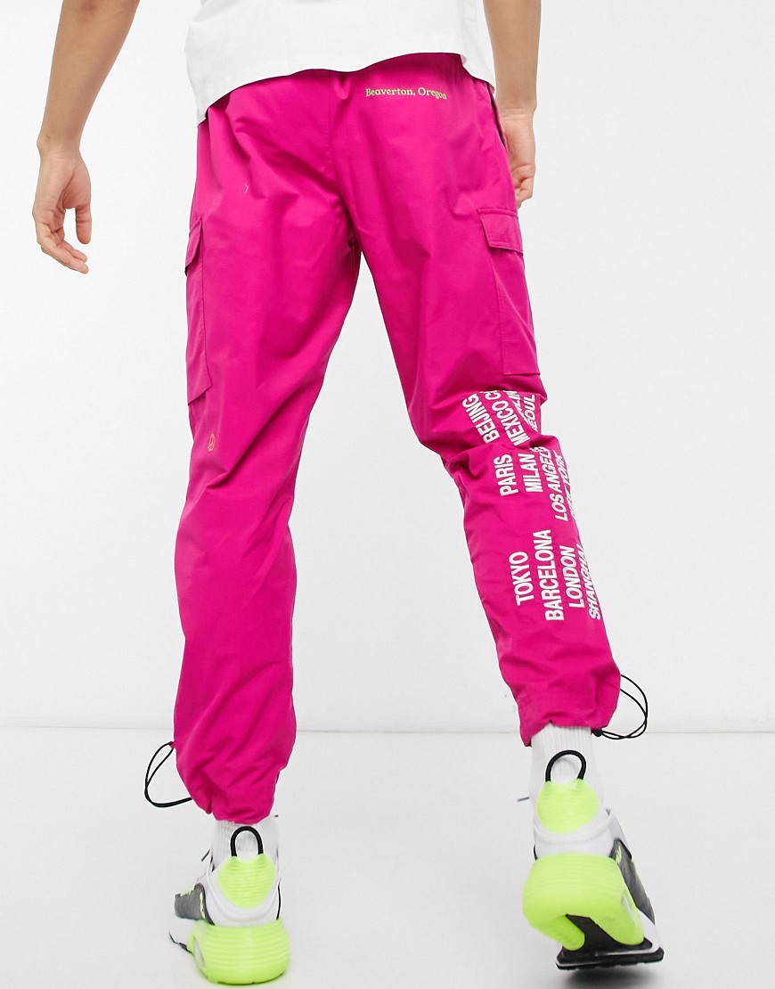 Nike – World Tour Pack – Rosa vävda cargobyxor med muddar och grafiskt tryck-Pink
