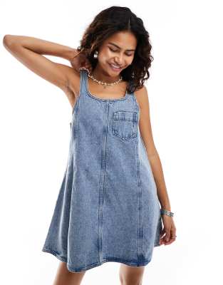 denim pinafore dress in mid wash blue