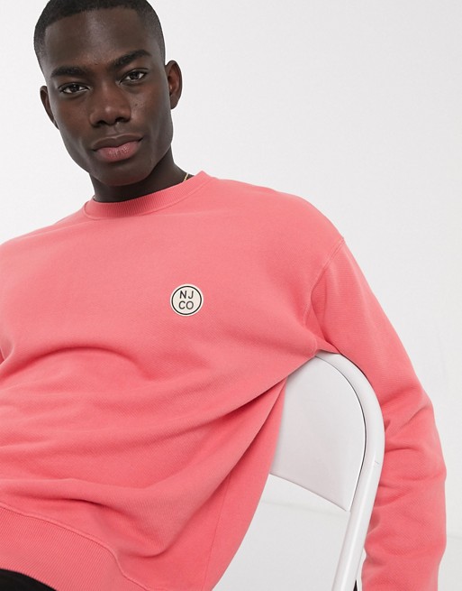 Nudie Jeans Lukas badge logo sweatshirt in pink