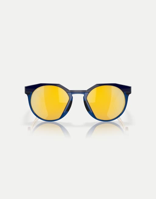 Oakley – Kylian Mbappé Signature Series HSTN – Runde, polarisierte Sonnenbrille in Marineblau/transparentem Blau mit goldfarbenen verspiegelten Gläsern