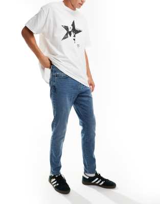 slim tapered fit jeans in mid blue wash