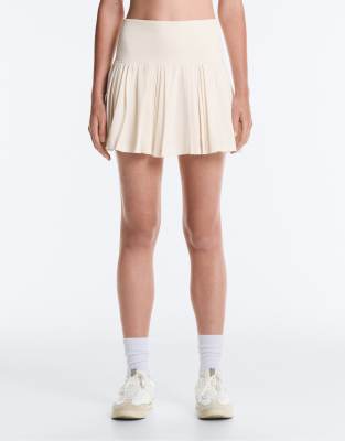 OYSHO – Blekt naturvit, plisserad, kort kjol i seamless design med hög midja — kjol med fickor från ASOS