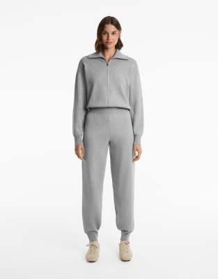 OYSHO - Langer Strick-Jumpsuit in Schwarz mit kurzem Reißverschluss