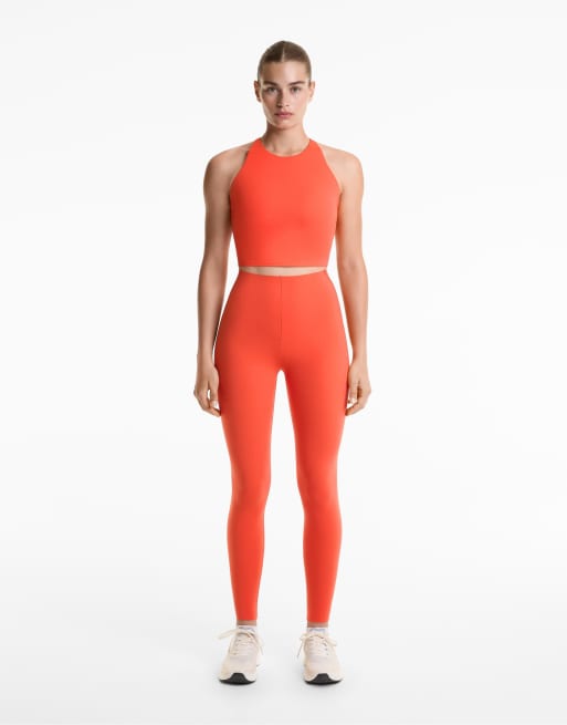 OYSHO - Leggings alla caviglia a vita alta contenitivi riflettenti con dettagli catarifrangenti arancioni