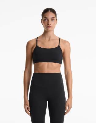 Oysho - Sport-BH aus Comfortlux in Schwarz mit leichter Stützfunktion und überkreuzten Trägern