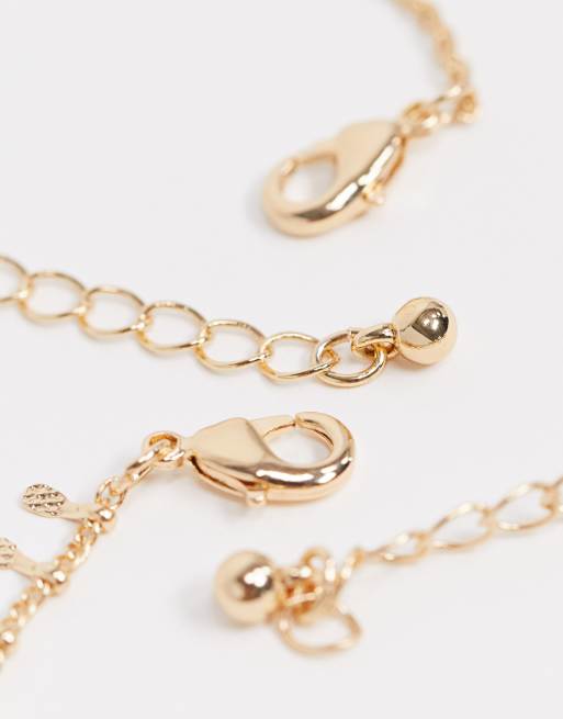 Pack de pulseras tobilleras con charms brillantes pequeños y plumas tono dorado de ASOS DESIGN | ASOS