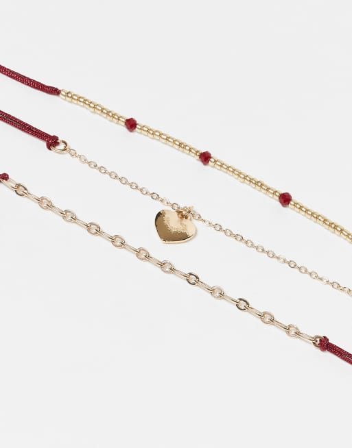 Pack de 3 tobilleras doradas con cordón rojo y charm de corazón de ASOS DESIGN, 2 de 3