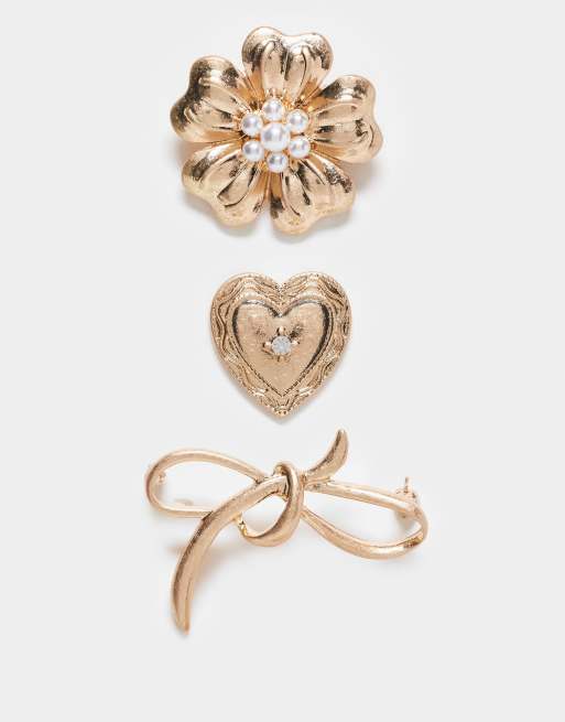 Pack de 3 broches dorado envejecido con diseño de flor, lazo y corazón de ASOS DESIGN