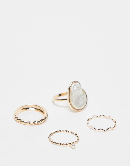 Pack de 4 anillos dorados con diseños de perlas de imitación de ASOS DESIGN Curve