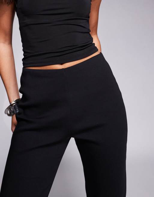 Pantalones capri negros con abertura lateral y detalle de lazo de