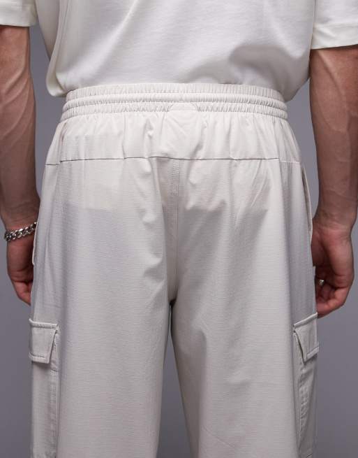 Pantalones cargo blanco hueso de tejido antidesgarros de New Balance, 4 de 5