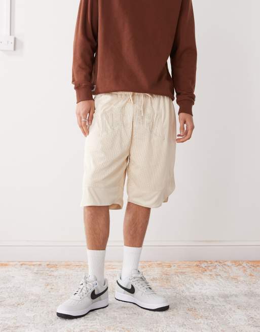 Pantalones cortos color crudo extragrandes de malla de New Era