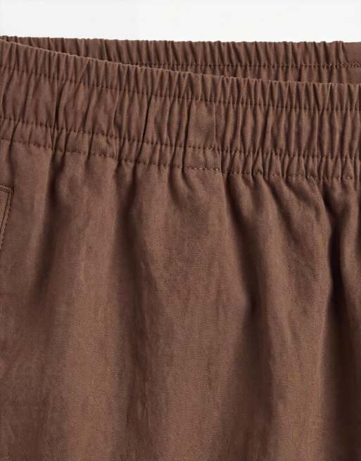 Pantalones cortos marrones de corte ancho y largo medio elásticos con ribetes de nailon de ASOS DESIGN, 9 de 9