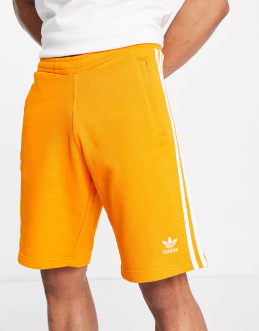 Pantalones cortos naranjas diseño de rayas adicolor de adidas |