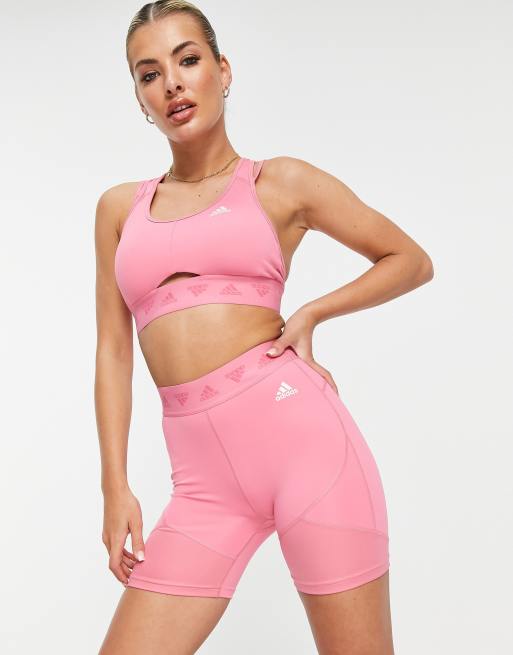Pantalones cortos rosa rosado con detalle de la marca en la
