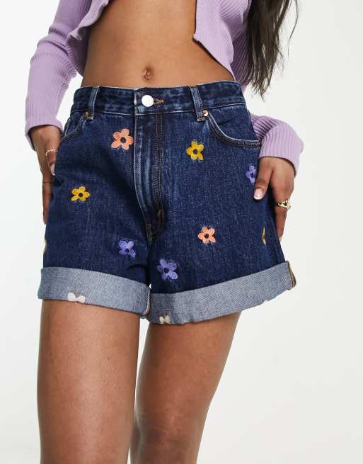 Pantalones cortos vaqueros azules con bordados florales y bajos vueltos de Monki