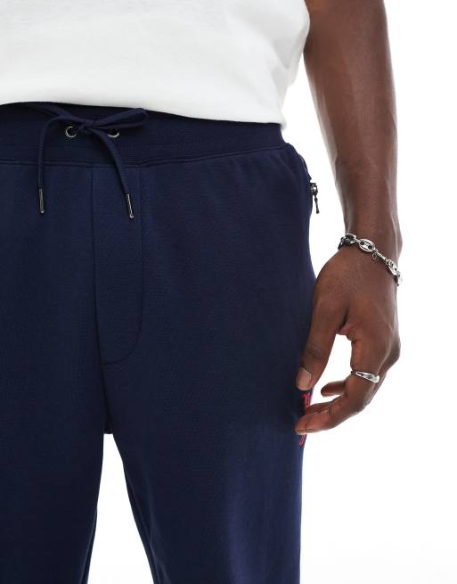Pantalones de chándal azul marino con detalle de banda y logo de P