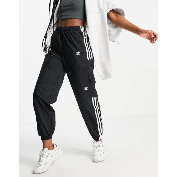 Pantalones de ch ndal negros con bolsillos y triple raya