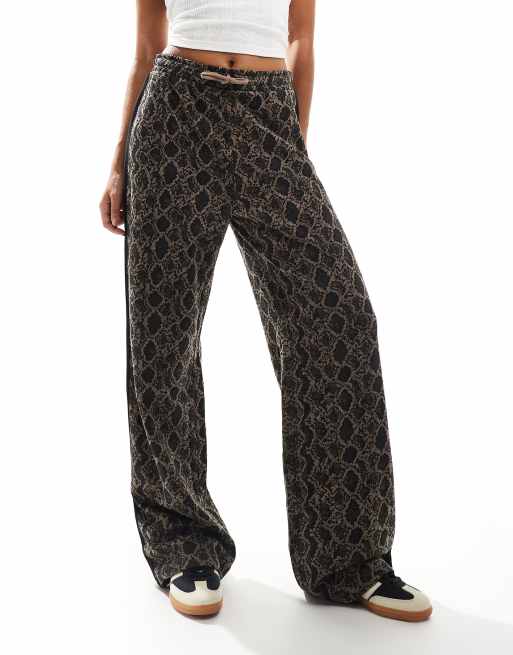 Pantalones marrones de pernera ancha con estampado de serpiente, cordón ajustable y detalle de banda negra en la parte trasera de Monki