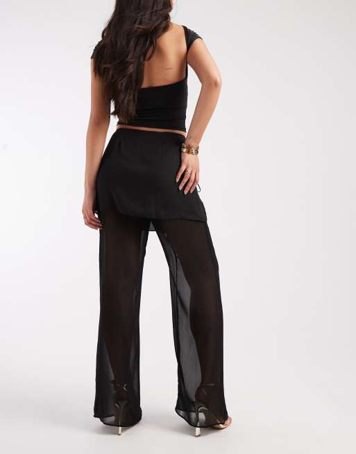 Pantalones negros con detalle de falda transparente superpuesta