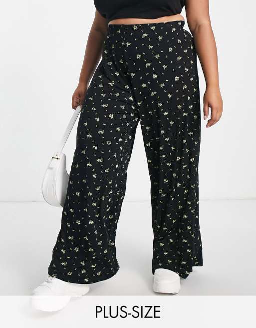 Pantalones negros de pernera ancha con estampado de florecitas exclusivos de Yours