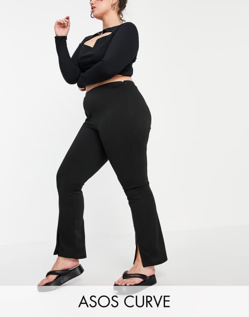 Pantalones negros elásticos de talle alto y corte pitillo abertura delantera de ASOS Curve | ASOS