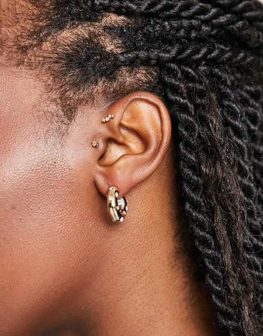 Pendientes de aro gruesos dorados con diseño abiertos y detalle de cristales de SVNX